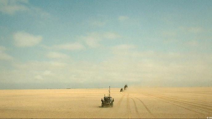 A lone car in a wide empty desert