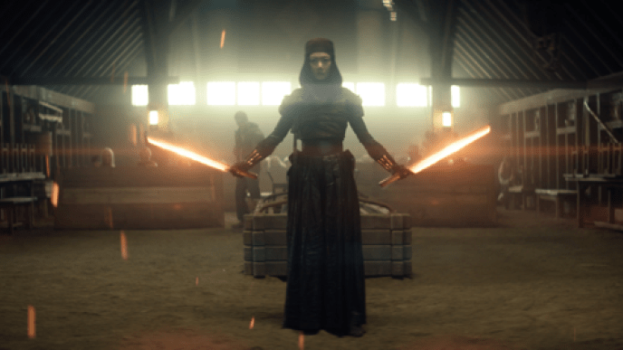 A woman standing with two glowing swords and robotic hands, there is a light shining from behind her.