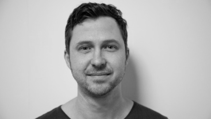 A black and white photo of Dom Hellier. Dom is wearing a dark t-shirt. 