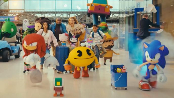 Video game characters like Pac Man and Sonic dash through a train station