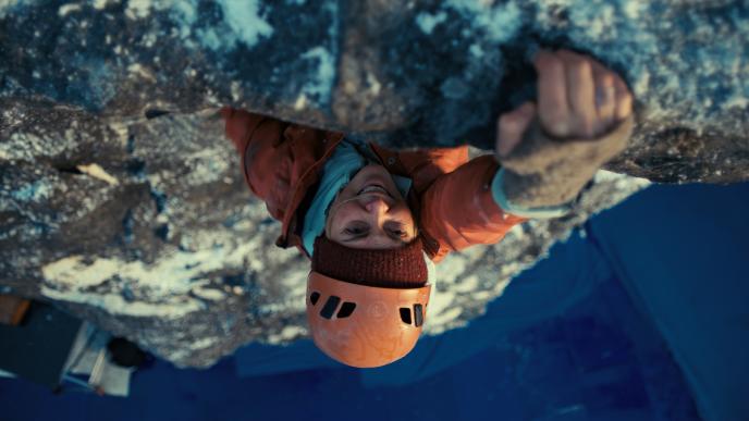 Plate photography of Charlize Theron climbing the Troll Wall set
