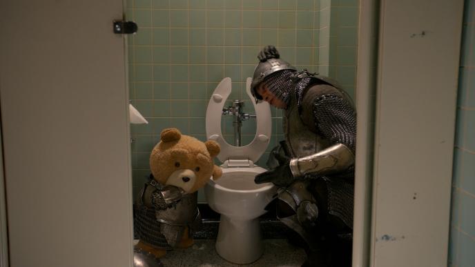 Ted and Johnny in guard costumes try to make themselves throw up the weed brownie before school play.