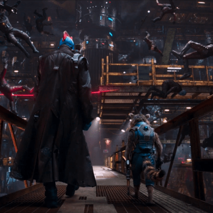 back view of yondu and rocket raccoon walking on a bridge as people fall to the ground