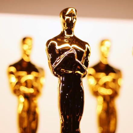 Gold Oscar statuettes lined up in rows