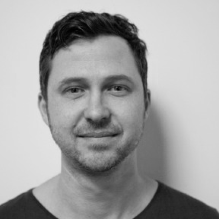 A black and white photo of Dom Hellier. Dom is wearing a dark t-shirt. 