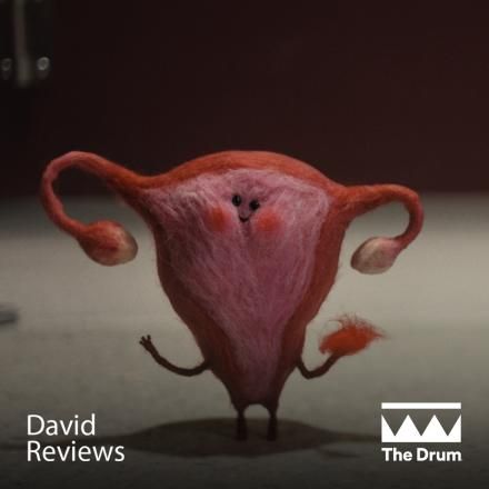 A small VFX felted uterus and ovaries with eyes and a face waving water the viewer, there are The Drum and David Reviews logos at the bottom.