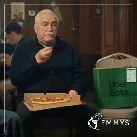 Brian Cox sitting eating pizza next to an Uber Eats bag.