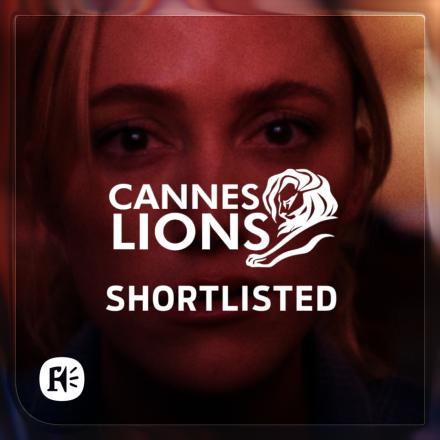A shot of a woman's face lit with pink light, there is a white Cannes Lions logo in the centre.