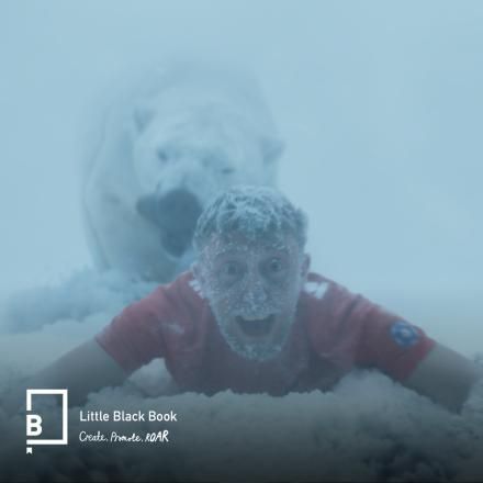 A still showing a footballer in the EAFC ad being dragged away from the camera by a plar bear.