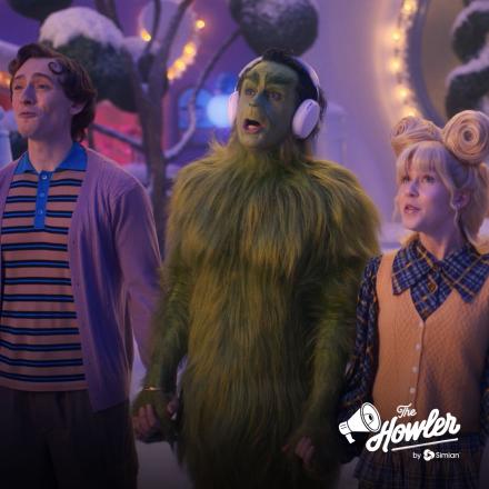 A still from Walmart's Whoknewville showing The Grinch, and there is a white The Howler logo in the bottom right hand corner.