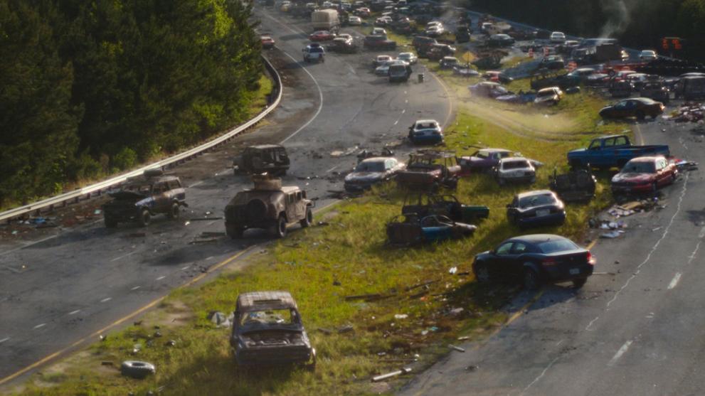A scene of destruction on a US highway with set extension in the background.