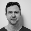 A black and white photo of Dom Hellier. Dom is wearing a dark t-shirt. 